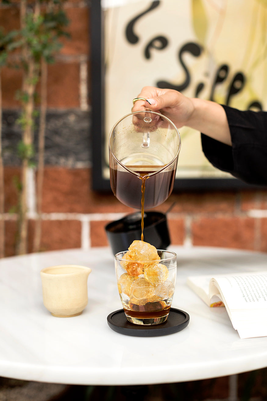 Verter café fresco sobre hielo en una cafetería